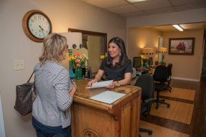 Smart Family Dentistryr handling a patient's insurance information