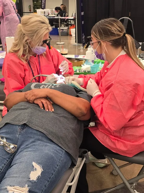 Two staff working on patient