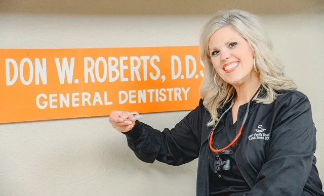 Dr. Lyndi Smart posing in front of old practice sign